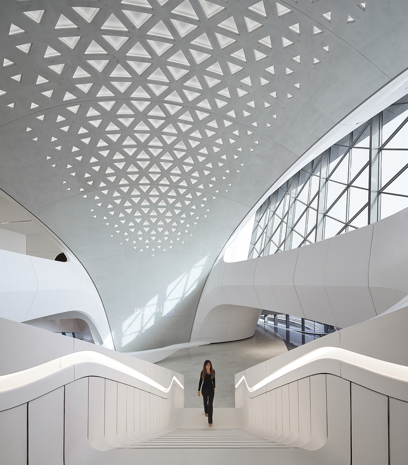 Zaha Hadid Architects interior design - Organic flowing architecture with geometric ceiling patterns and curved staircases showcasing bioclimatic design excellence